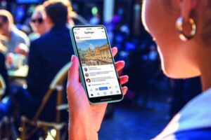 une femme tient un téléphone portable et regarde son compte instgram